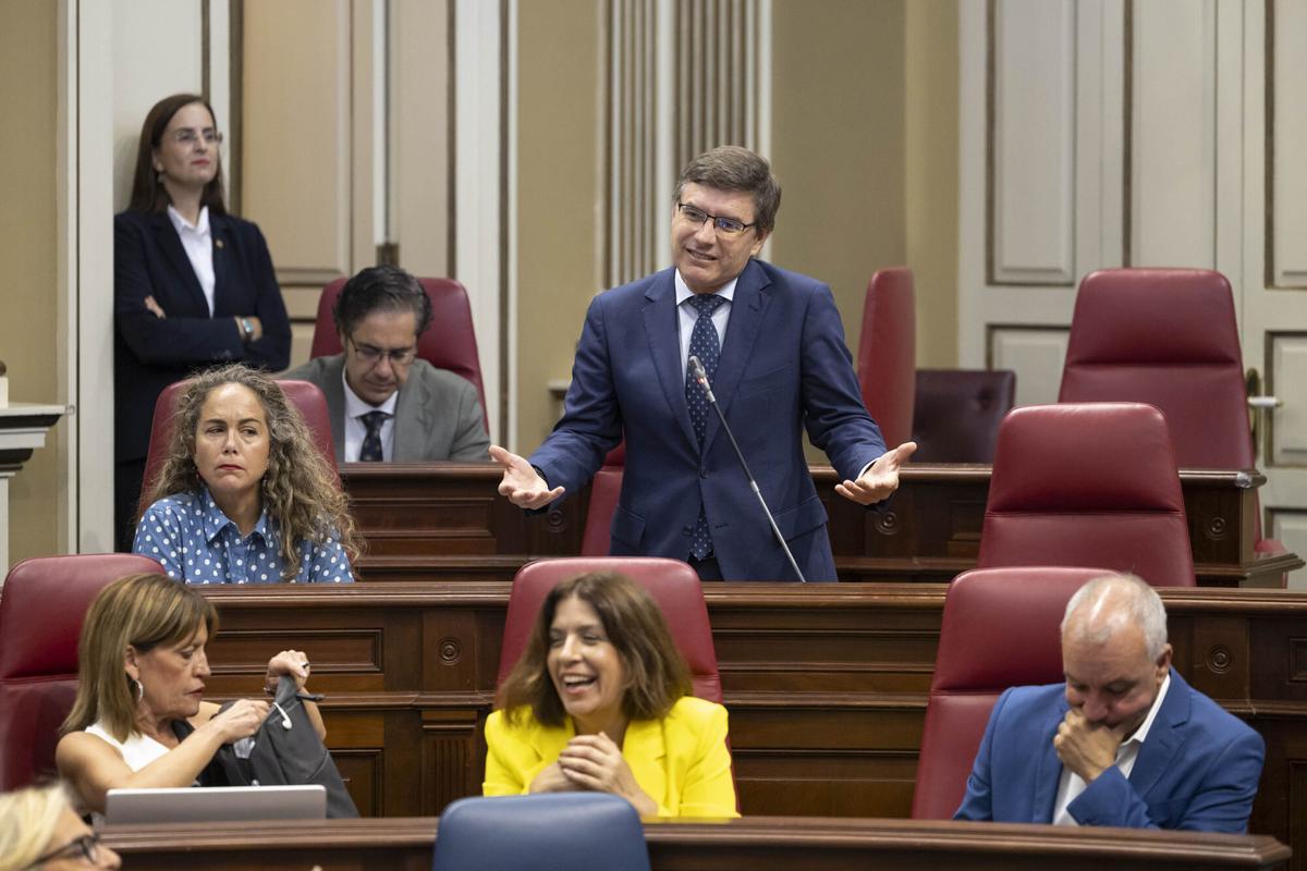 El portavoz del Vox en el Parlamento de Canarias, Nicasio Galván (c, de pie), se dirige al presidente del Gobierno, Fernando Clavijo, durante el pleno que celebra este martes la Cámara autonómica.