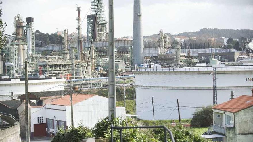 Algunas viviendas de Nostián, con la refinería al fondo.