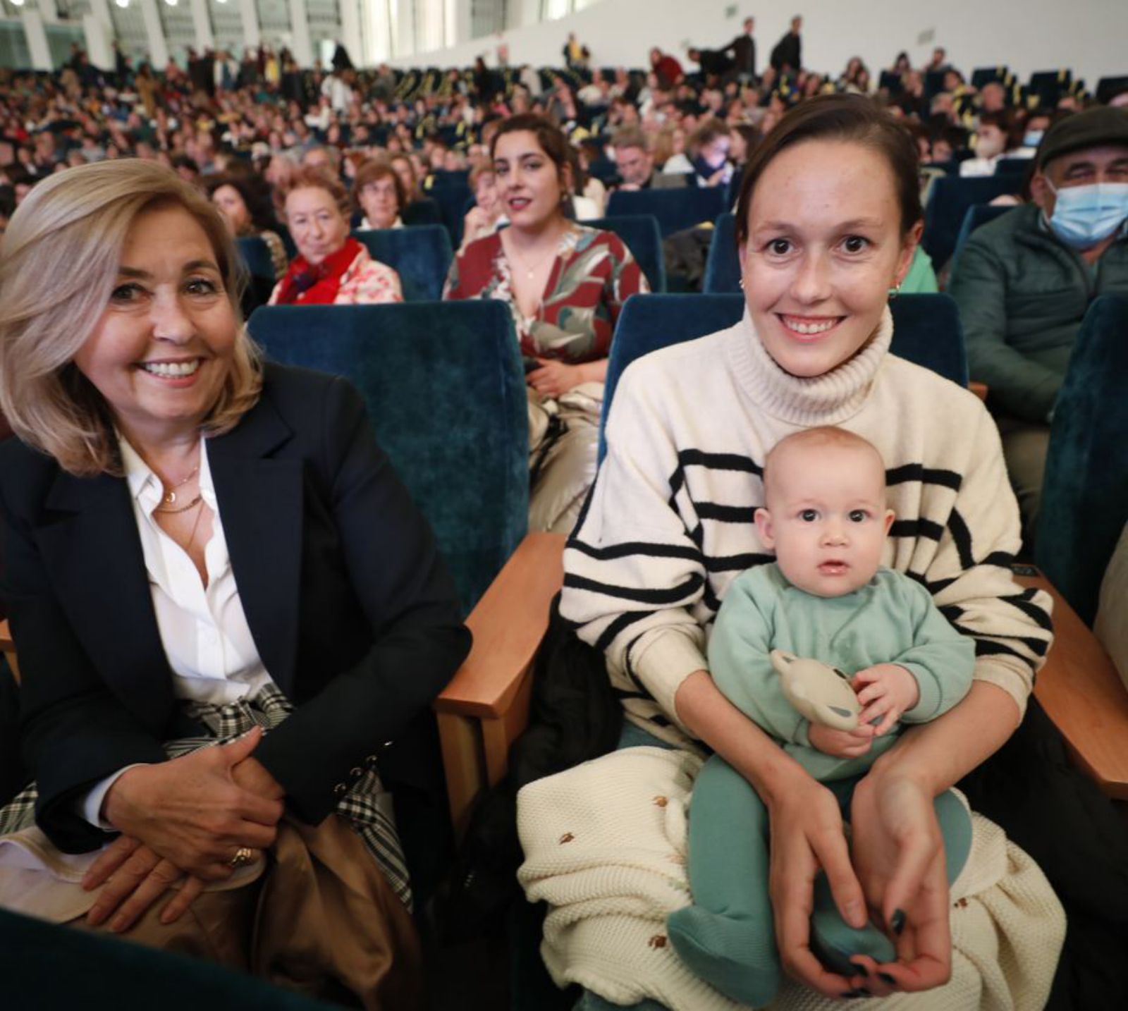 En el centro, Virginia García-Terente Fernández con su hija Olivia, de cuatro meses y medio, la más joven del público, ayer, en Oviedo. | Luisma Murias