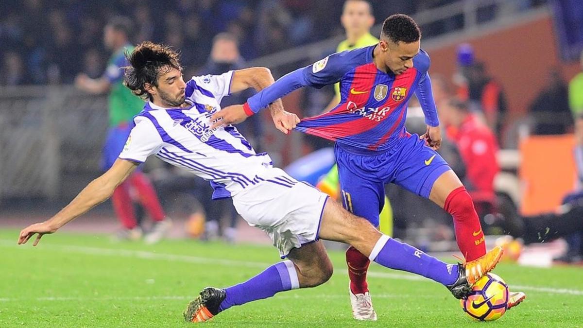 Carlos Martínez, de la Real Sociedad, lucha con Neymar.