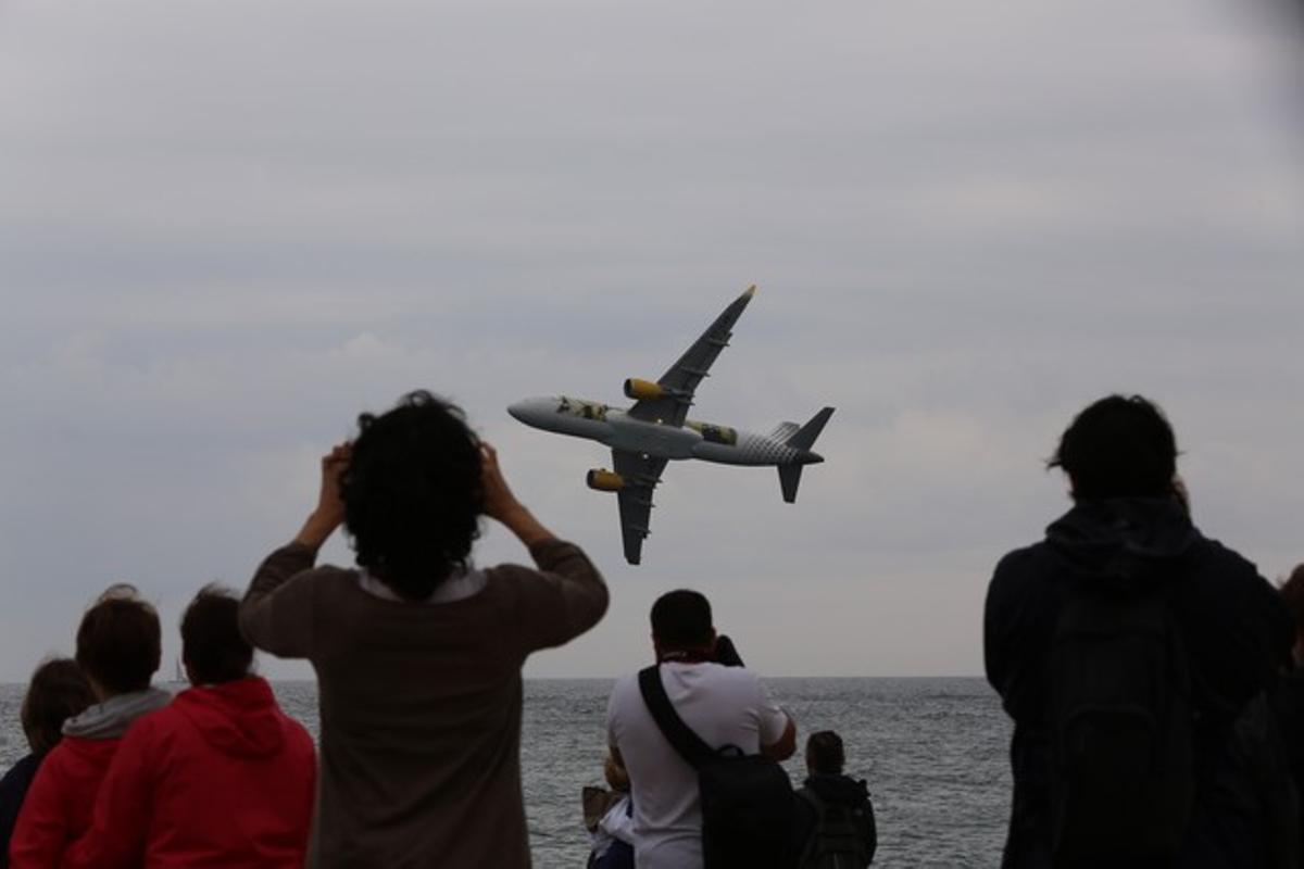 Diverses persones contemplen l’Airbus 320 de Vueling, aquest diumenge a la Festa del Cel, a Mataró.