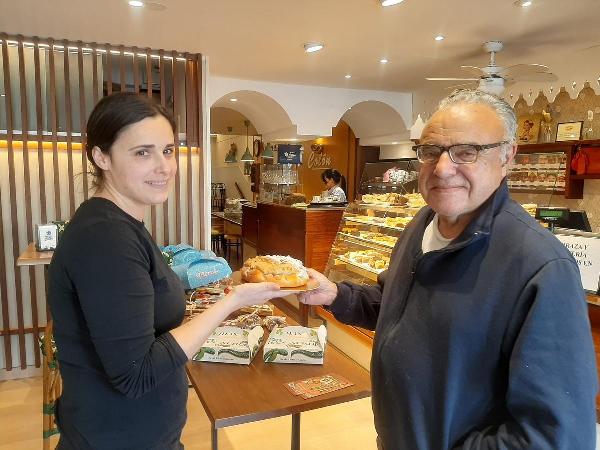 Clara Sánchez entrega una rosca dulce a Javier Ballina en la Confitería Colón