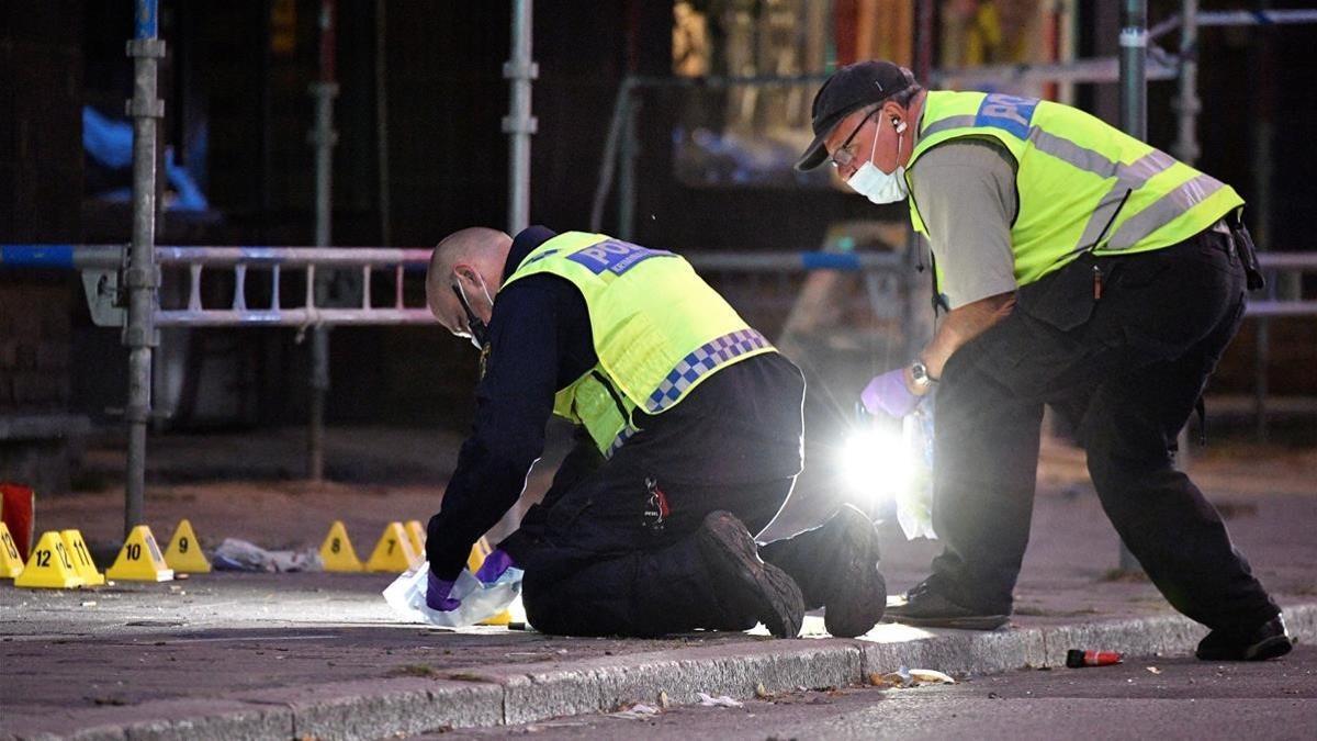 Policías forenses trabajan en el lugar en el que un grupo de personas resultaron heridas por arma de fuego en el centro de Malmo, Suecia.