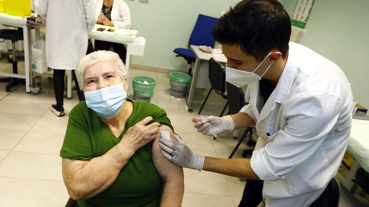 Una mujer recibe la vacuna del covid y la gripe en un centro de salud.