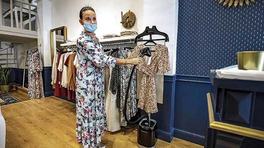 Floriana Poirier, de la tienda de ropa Les Filles au Soleil, desinfecta una prenda con una mÃ¡quina de vapor.