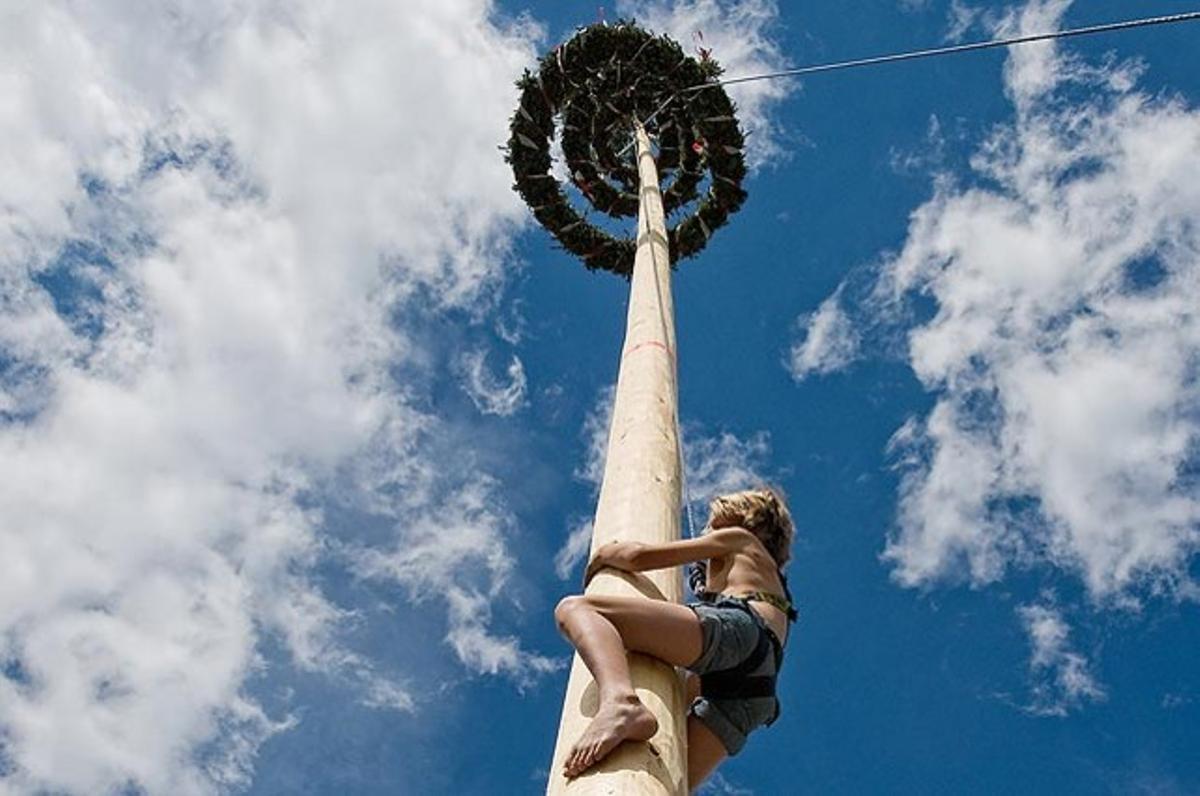 Un nen grimpant a un arbre durant les festes tradicionals del Primer de Maig a Lofer, província de Salzburg (Àustria).
