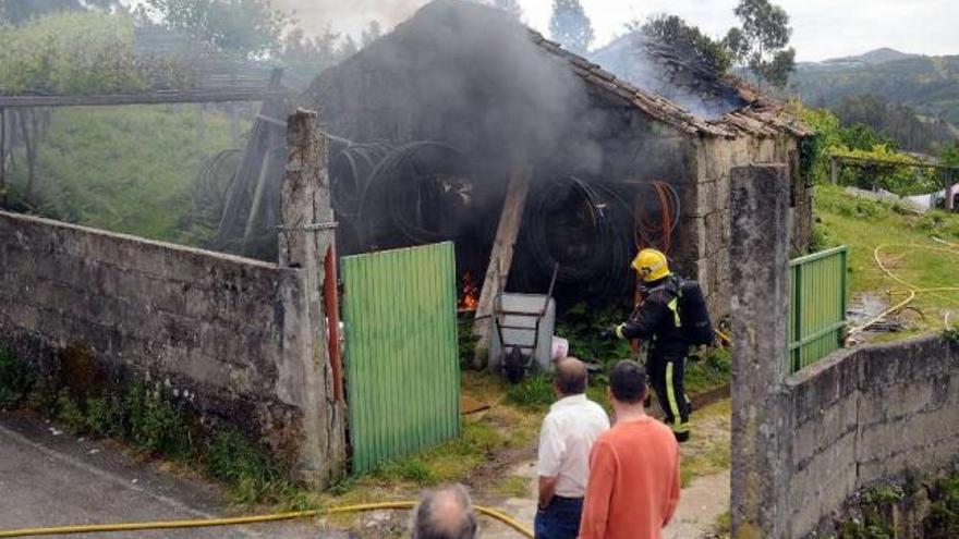 Los vecinos observan a los bomberos durante su intervención ayer en esta vivienda.  // Rafa Vázquez