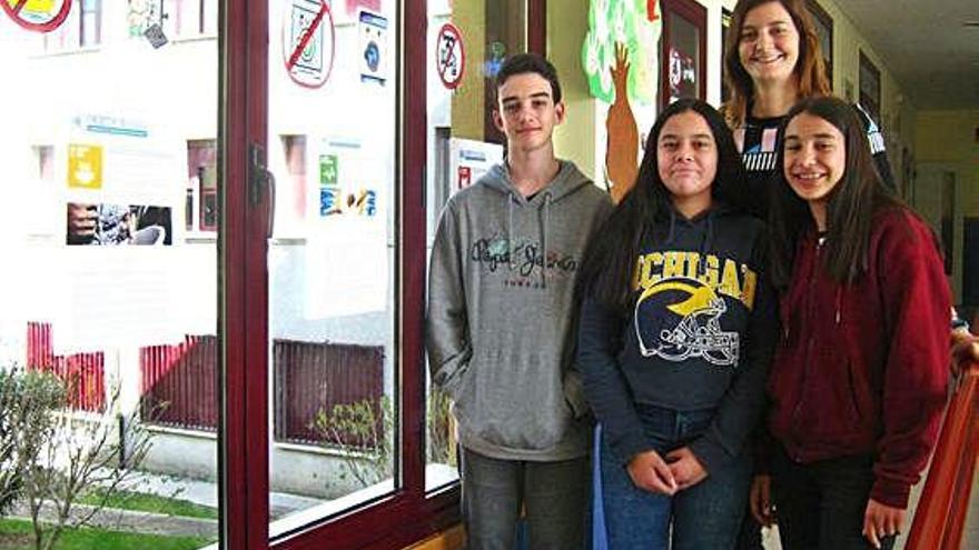 Los tres alumnos y la profesora que expondrán el proyecto posan en el instituto toresano.