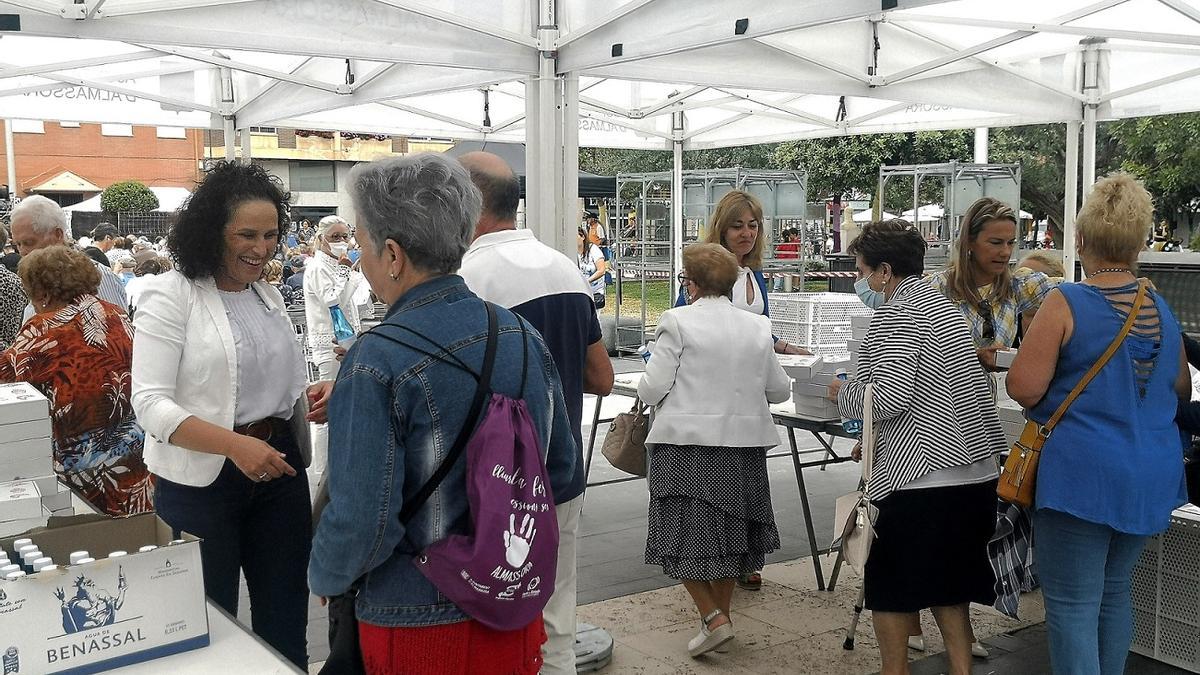 La alcaldesa, Merche Galí (i), reparte las meriendas a los mayores en la plaza Pere Cornell, este martes.