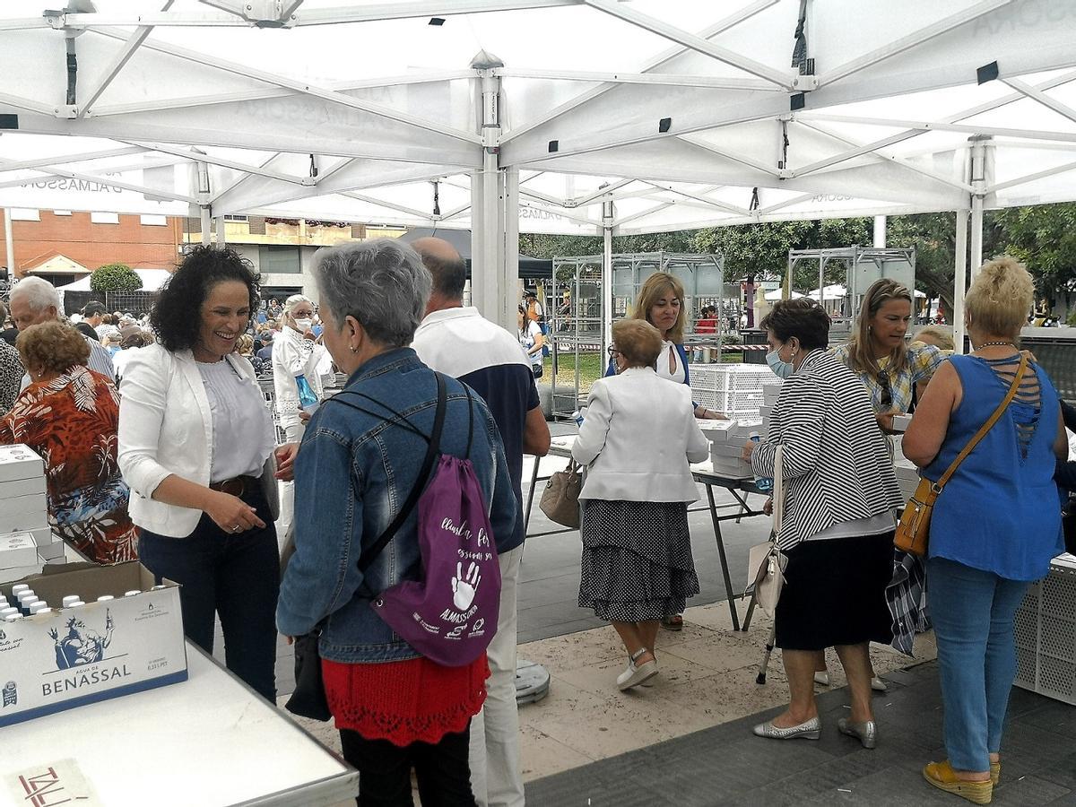 La alcaldesa, Merche Galí (i), reparte las meriendas a los mayores en la plaza Pere Cornell, este martes.