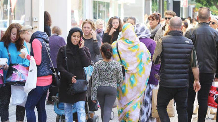 Ciudadanos paseando por una calle comercial de Ibiza.