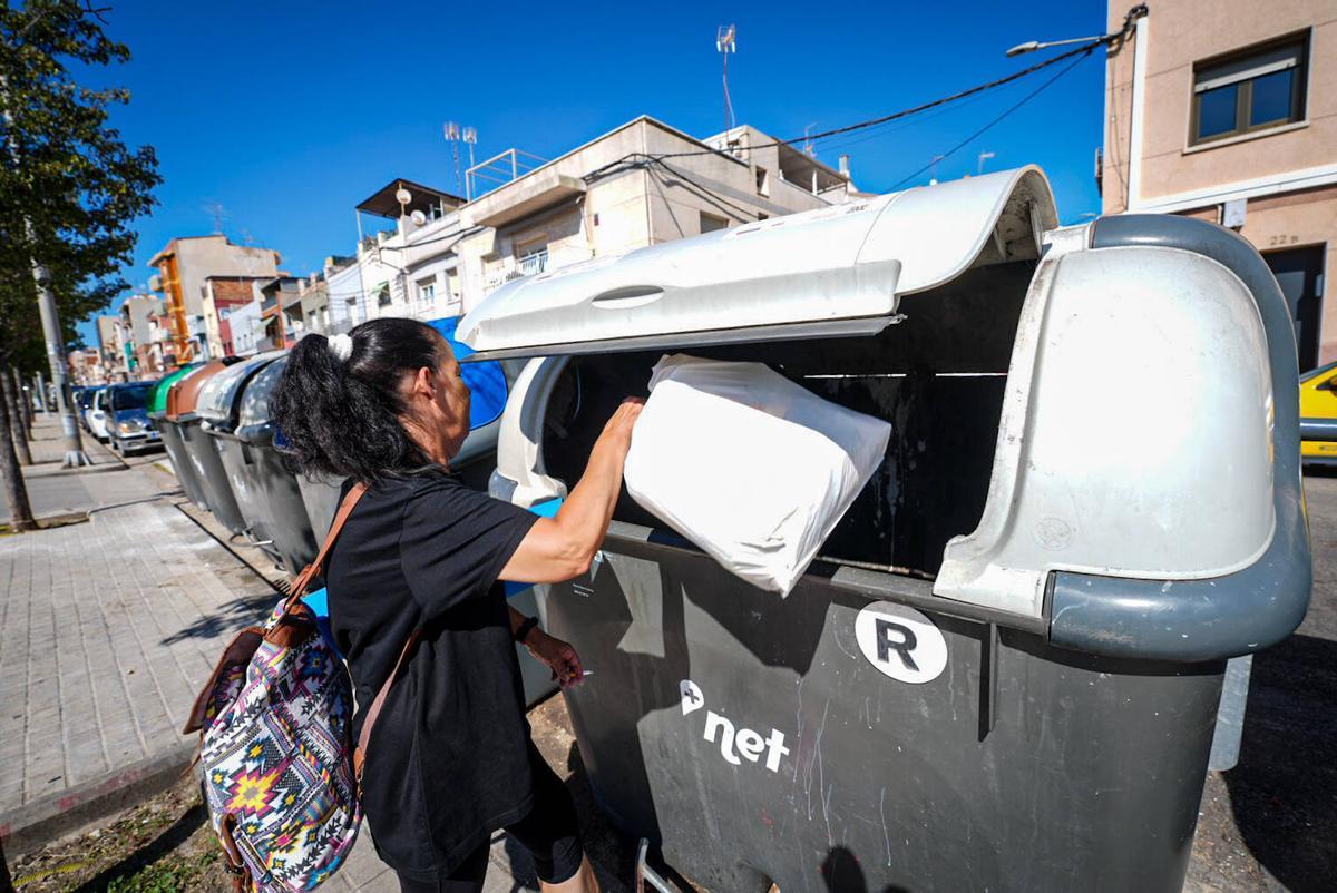 Una mujer tira la basura en uno de los contenedores de la ciudad. Foto archivo