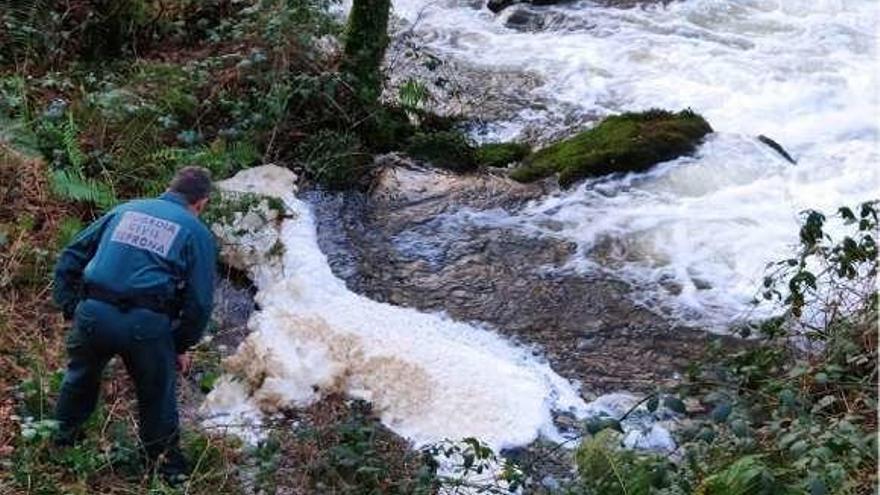 Agua espumosa en el río, donde desemboca el vertido de purines.