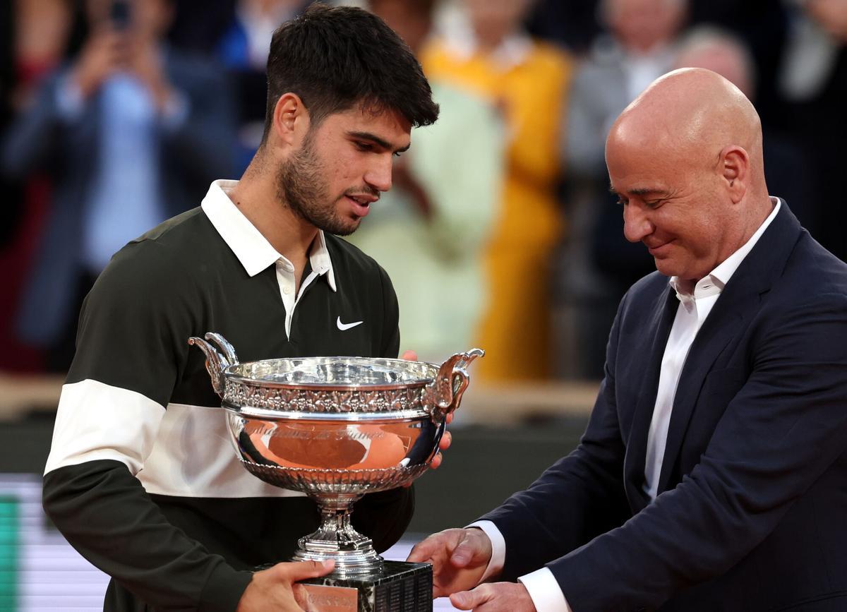 PARIS (France), 08/06/2025.- Carlos Alcaraz of Spain receives the Coupe des Mousquetaires from former US tennis player Andre Agassi after winning his Men's final match against Jannik Sinner of Italy at the French Open Grand Slam tennis tournament at Roland Garros in Paris, France, 08 June 2025. (Tenis, Abierto, Francia, Italia, España) EFE/EPA/MOHAMMED BADRA
