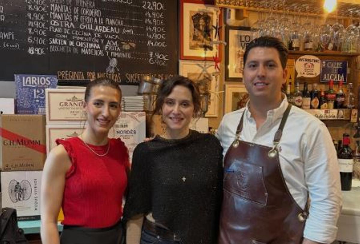 Los propietarios de la Tasca La Ultramarina posando con Isabel Díaz Ayuso en el interior del bar