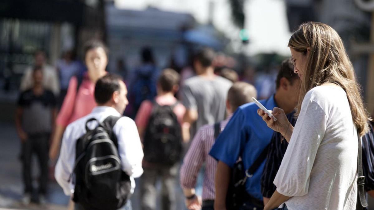 Una mujer utiliza su teléfono móvil en plena calle.  | EFE