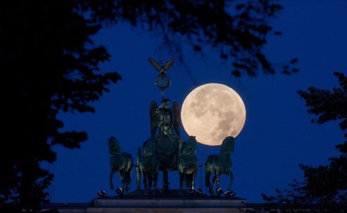 Detalle de la puerta de Brandenburgo, en Berlin, con la luna en su plenitud.