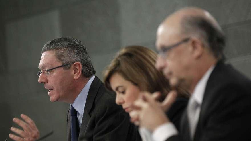 Gallardón, con Sáenz de Santamaría y Montoro, ayer, tras el Consejo de Ministros.  // Efe