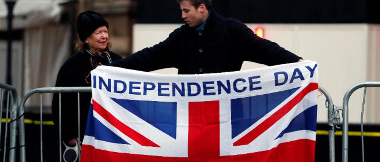 Un ciudadano sostiene en Downing Street una bandera de Reino Unido bajo el lema &#039;Independence Day&#039;.
