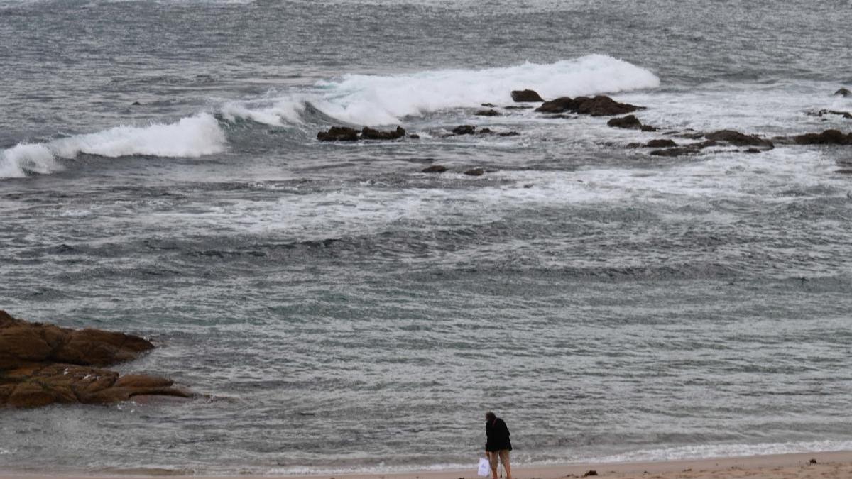 Una mujer pasea por la orilla de la playa, ayer en A Coruña.