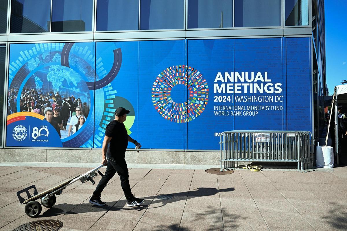 Un operario pasa delante de la sede de la Asamblea Anual de 2024 del FMI y del Banco Mundial, en  Washington.