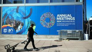 Un operario pasa delante de la sede de la Asamblea Anual de 2024 del FMI y del Banco Mundial, en  Washington.