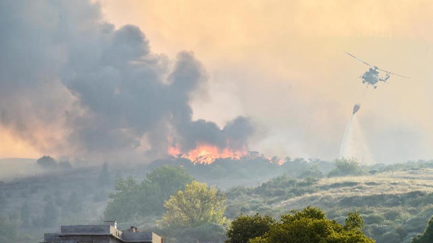 Las llamas devoran los pinos en una panorámica desde Santa Brígida a la cumbre, mientras un helicóptero de los nueve que operaron en el siniestro lanza agua con la cuba, ayer.