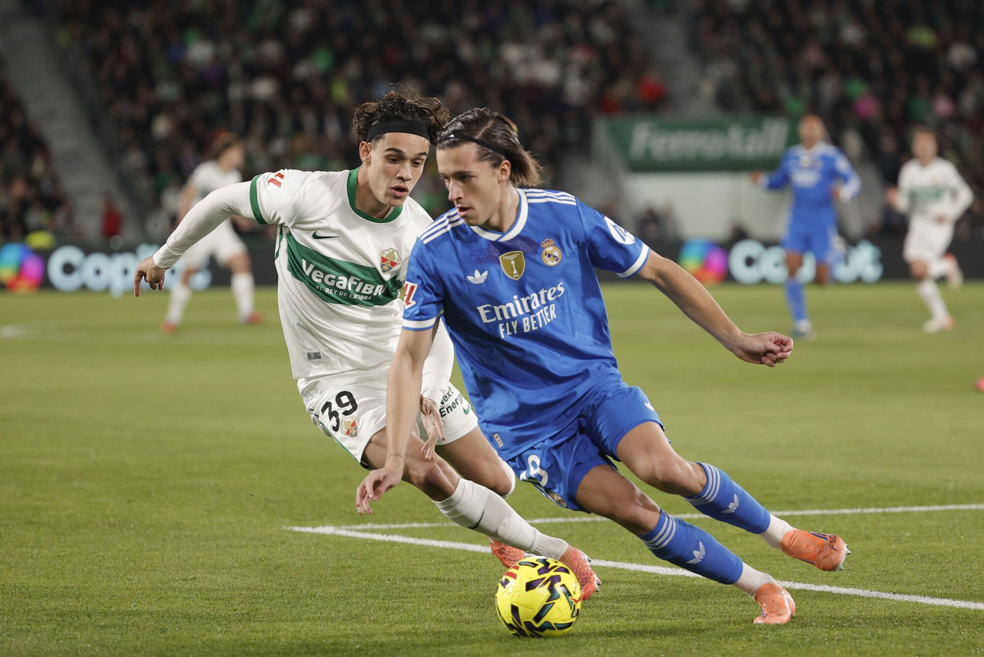 ELCHE (ALICANTE), 23/11/2025.- El defensa del Real Madrid Álvaro Carreras (d) pelea un balón con el defensa del Elche C.F Héctor Fort durante el partido de LaLiga, este domingo en el estadio Martínez Valero. EFE / Manuel Bruque
