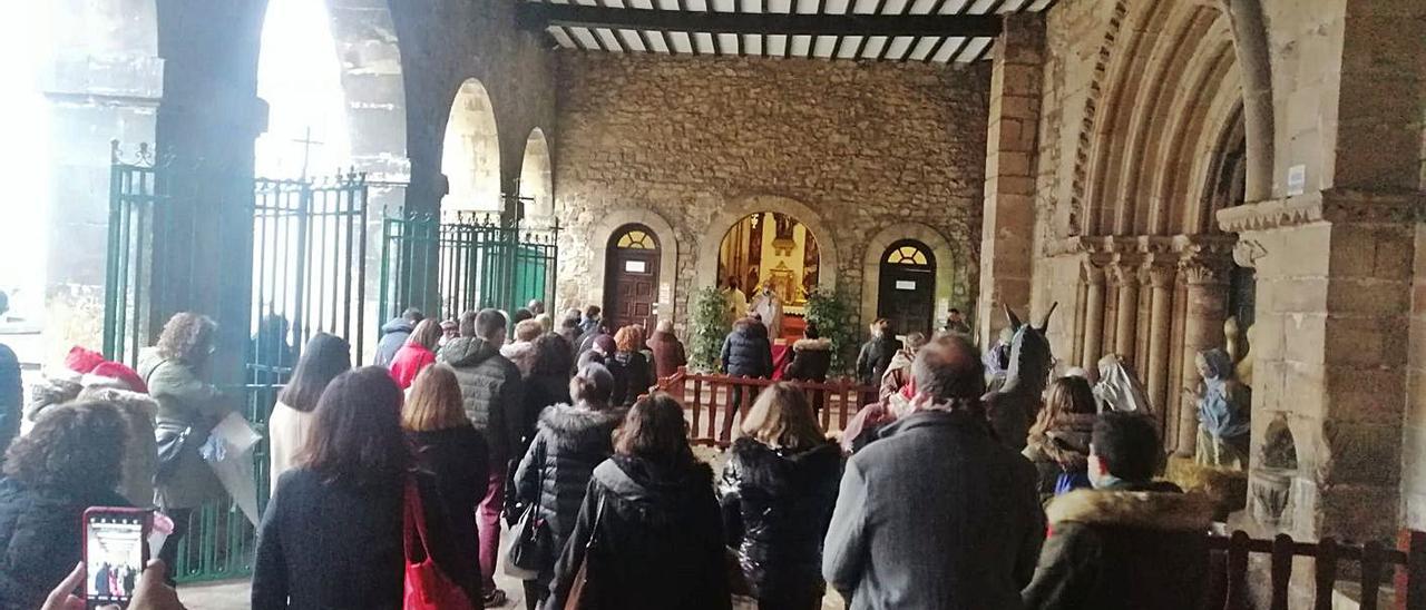 En la foto superior, reparto de la Luz de Belén en la iglesia de San Nicolás y a la izquierda, un voluntario de la Fraternidad de Francisco.