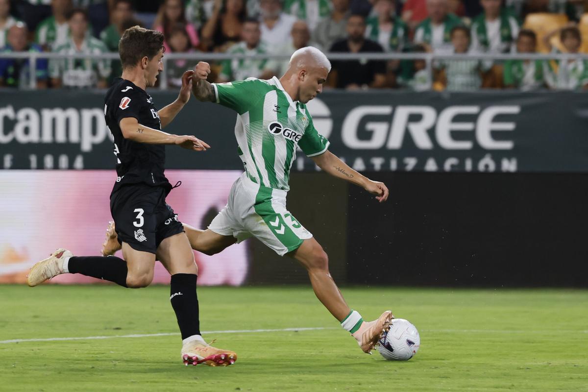 Pablo García dispara ante Aihen Muñoz durante el partido de LaLiga que Real Betis y Real Sociedad han disputado este viernes en el estadio de La Cartuja