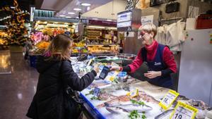 Elisenda Goño, pescadera del Mercat de la Concepció, cobra a una clienta.