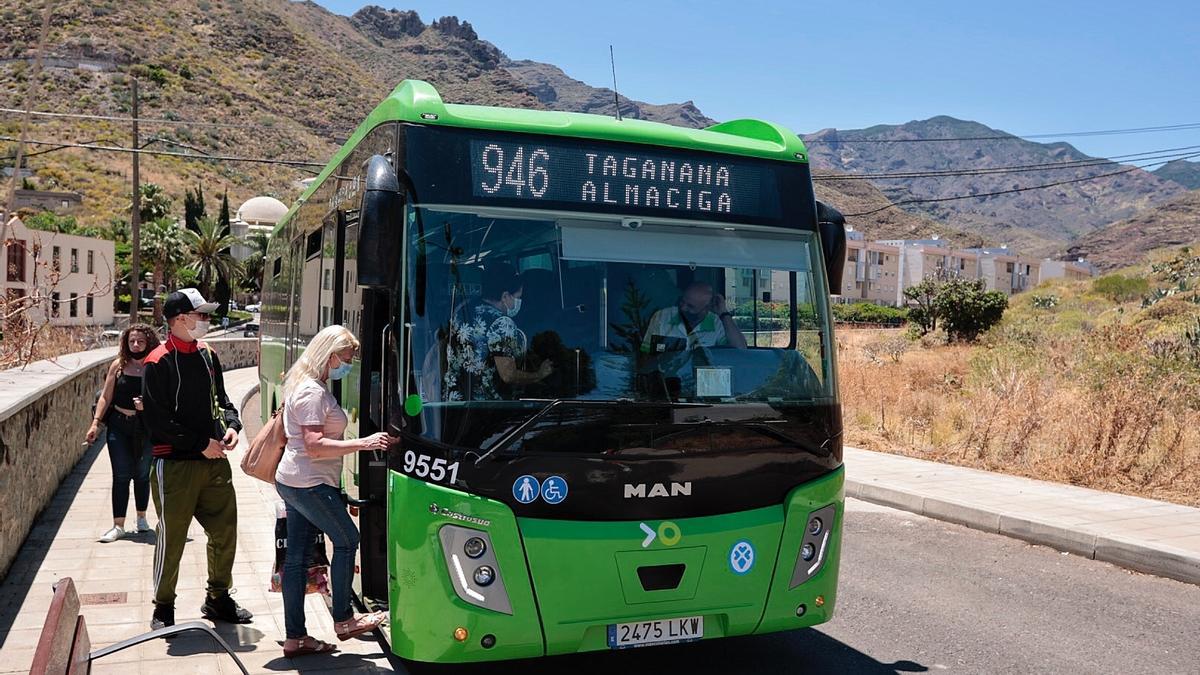 Dos usuarios acceden a una guagua en Santa Cruz de Tenerife.