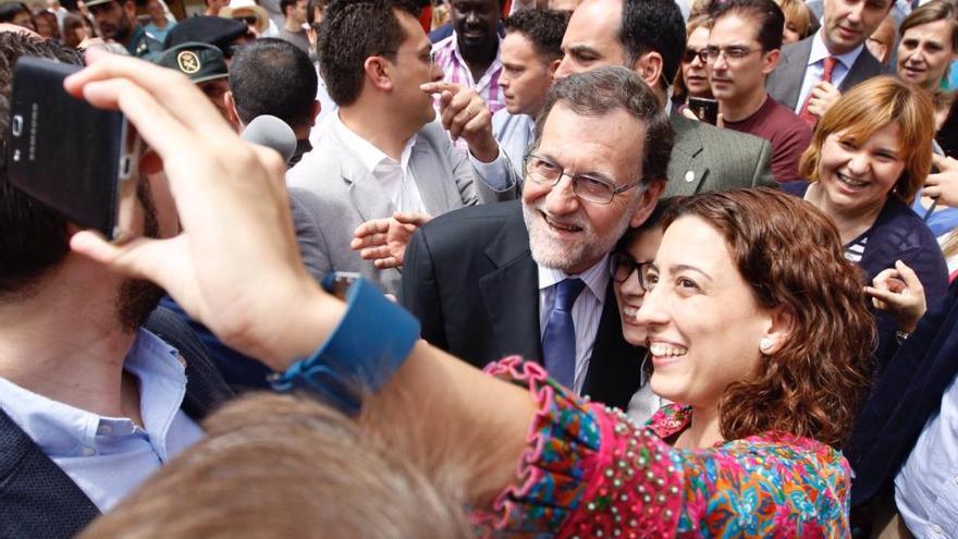 Rajoy se toma una foto con una mujer durante su visita a Alfafar.