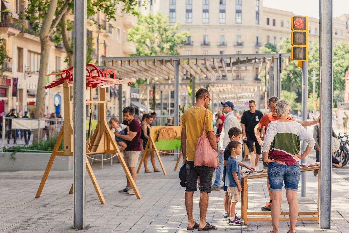 Parc infantil de fusta amb famílies en la inauguració de la ronda de Sant Antoni