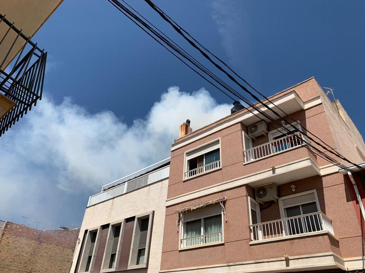 La humareda procedente de la terraza de la vivienda incendiada.