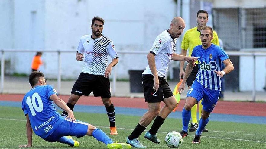 Ríchard controla el balón entre dos jugadores de la Ponferradina con Noel Alonso al fondo.