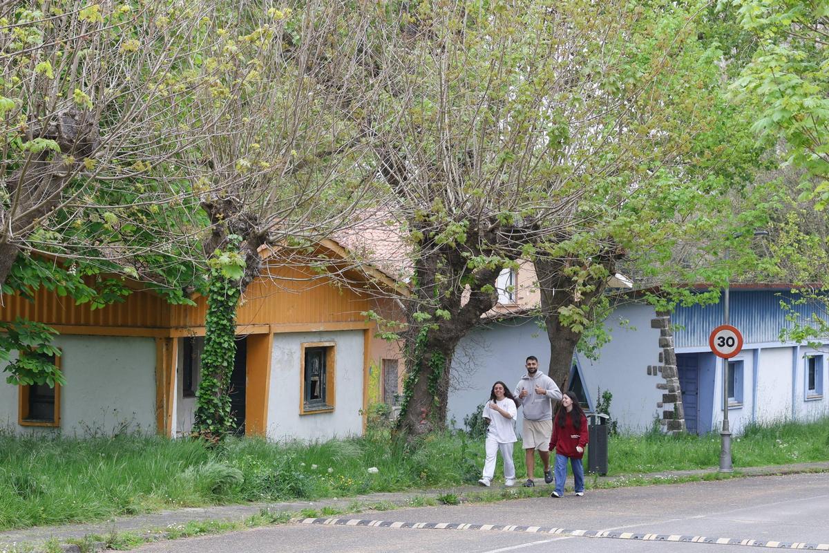 Tres caminantes en la Ciudad Residencial de Perlora, en Carreño.