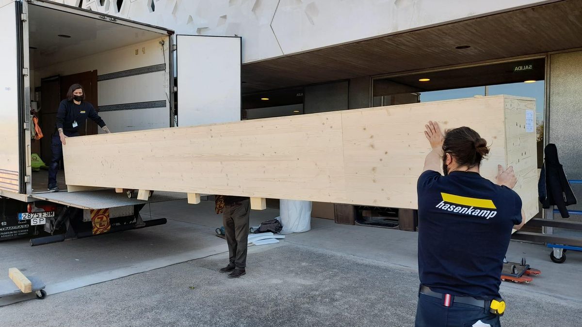 Dos operarios descargan de un camión una de las obras de 'Futuros abundantes' en el C3A.