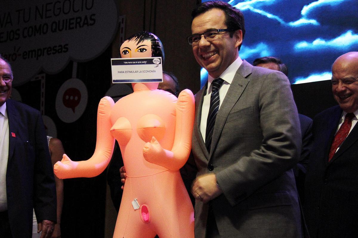 Chile’s economy minister Luis Cespedes holds up an inflatable doll during an event of the exporters’ association Asexma in Santiago, Chile, December 13, 2016. Picture taken December 13, 2016. The sign reads To stimulate the economy. REUTERS/Jorge Cadenas Lorca   FOR EDITORIAL USE ONLY. NO RESALES. NO ARCHIVE.     TPX IMAGES OF THE DAY