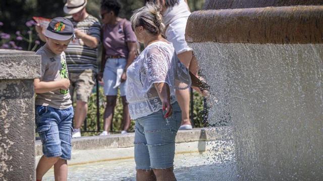 Gent refrescant-se en una font de Barcelona, aquest juliol. | MANU MITRU