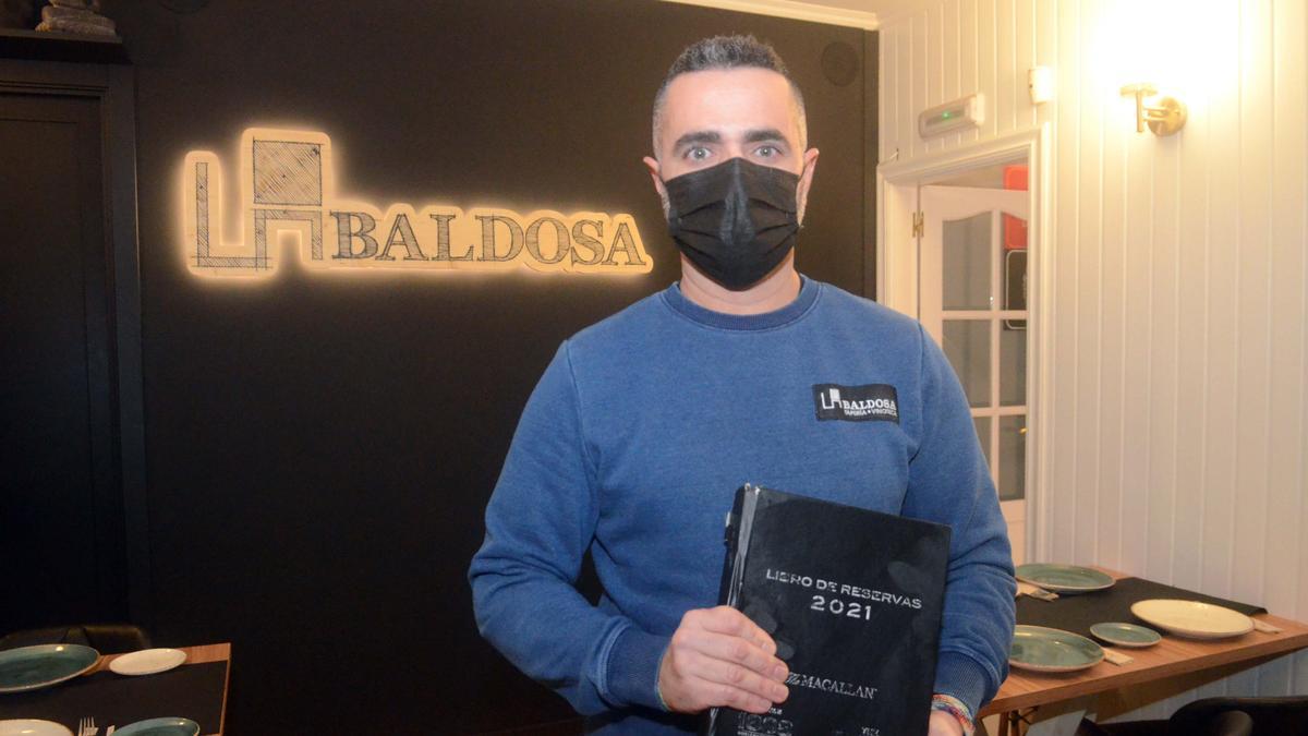 Manuel Gómez, del restaurante La Baldosa, con el libro de reservas de su negocio.