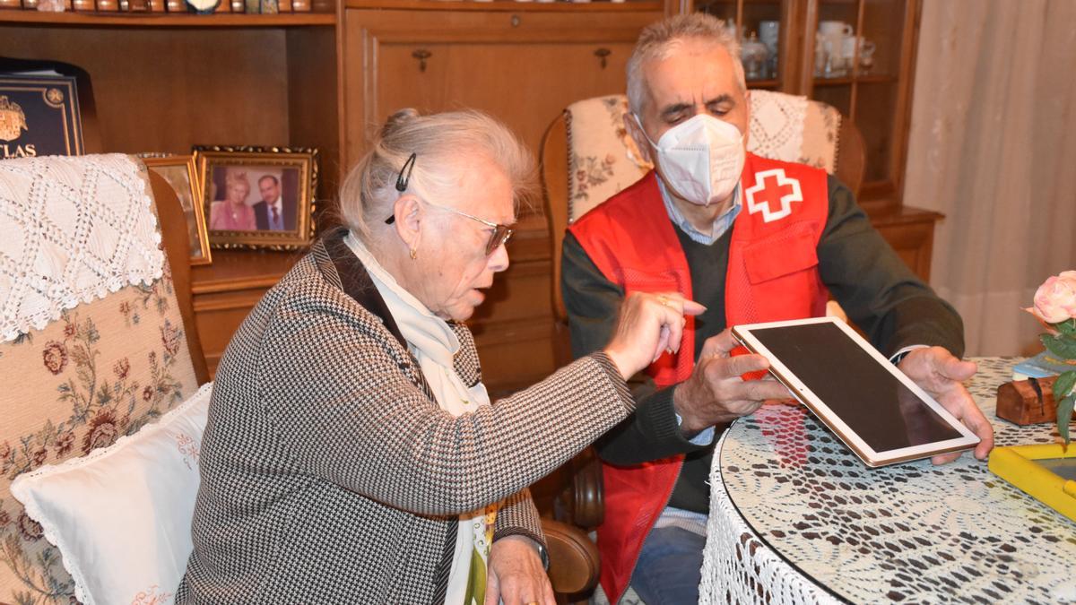 Un voluntario de Cruz Roja con una persona mayor.