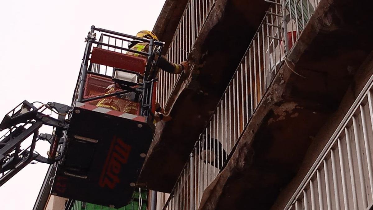 Els bombers treballant en el balcó afectat