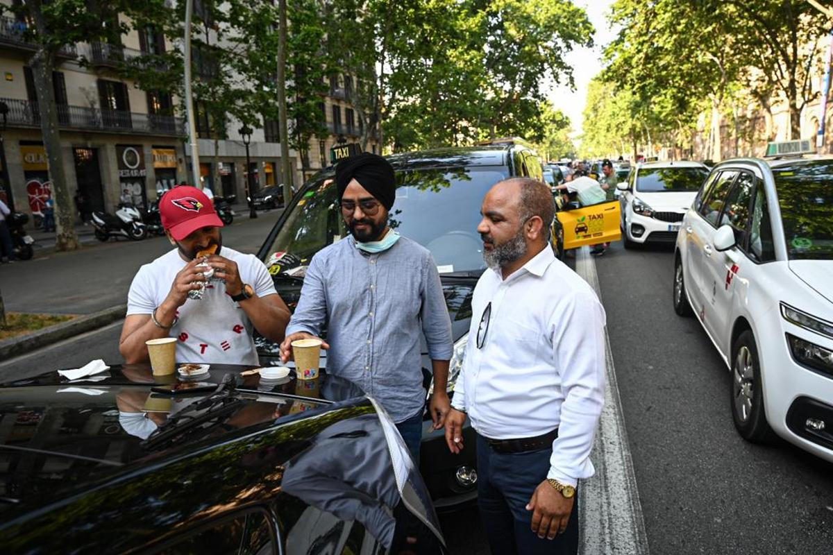 Unos taxistas se toman un café mientras están parados en la Gran Via