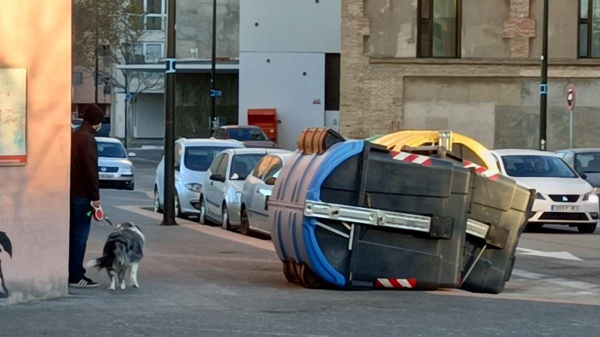 Contenedores derribados por el viento en la calle Más de las Matas de Zaragoza.