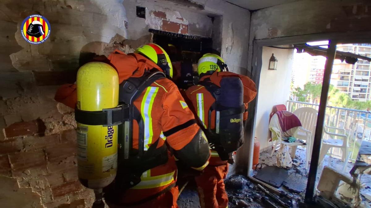 Dos bomberos, esta tarde, en el interior de la vivienda siniestrada.