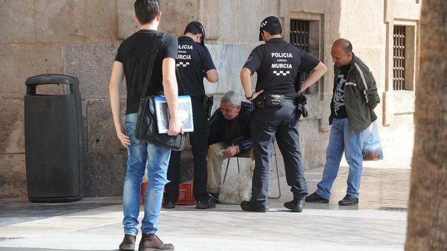 Dos agentes de la Policía Local identifican a un transeúnte que pretendía vender unos cachorros.