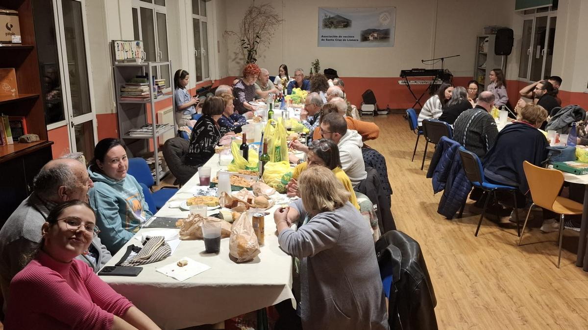 Varios socios de la Asociación de Vecinos de Santa Cruz, disfrutan del bollo en el centro social de la parroquia.