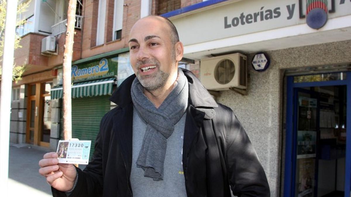 Uno de los responsables de la administración de lotería número 6 de Cornellà, enseña el número del quinto premio.