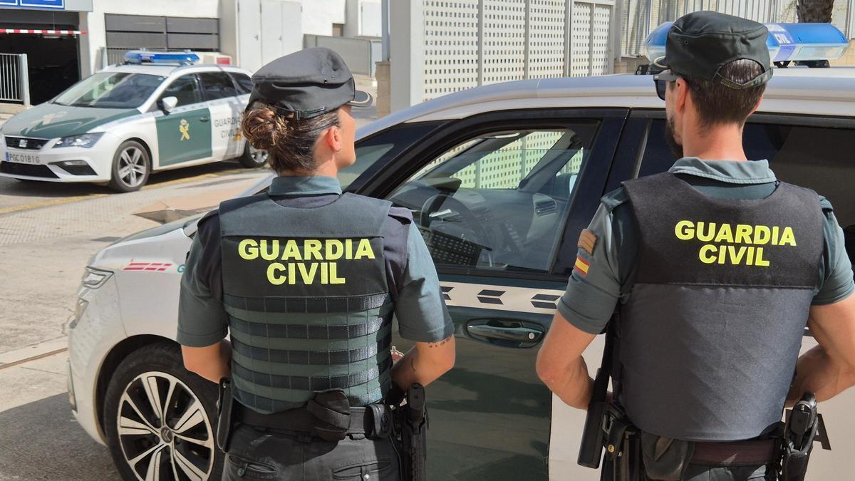 Agentes de la Guardia Civil ante el coche patrulla.